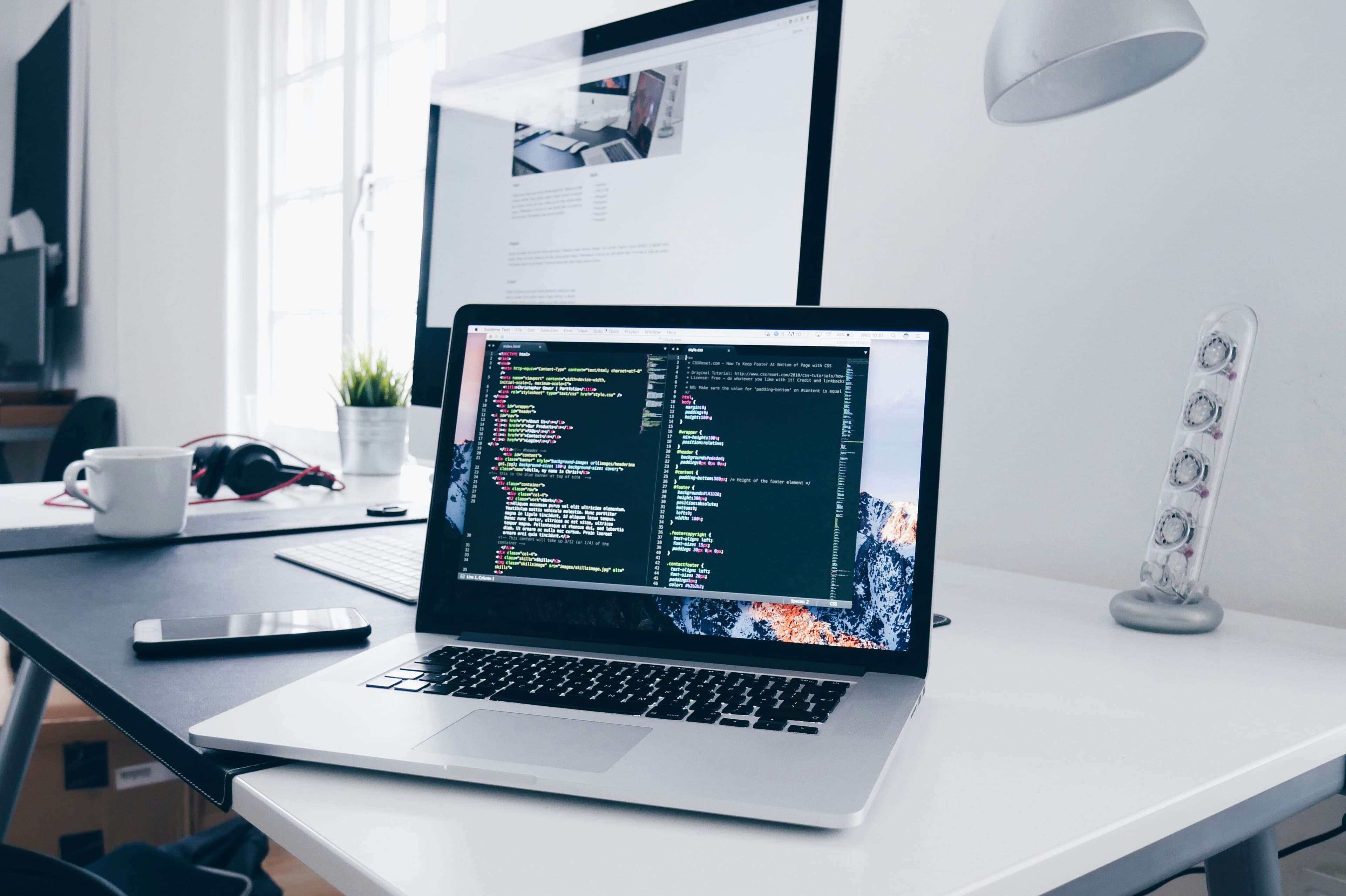 Developer workspace with code and interface panels on screens